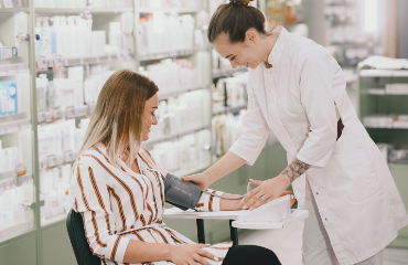 Foto/Grafik Quelle: shutterstock.com [2010554801 Praktikant, der den Blutdruck seines Kunden in der Apotheke nimmt © Oleggg] 
