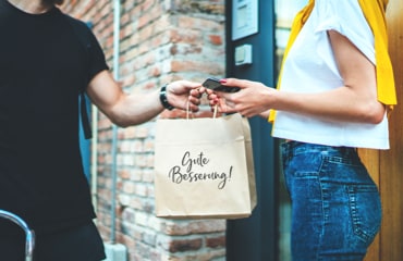 Foto/Grafik Quelle: shutterstock.com [1336905017 Anonimous Fahrradverleih Essen Service zu Hause. Ein Kurier lieferte die Bestellung ohne Namensbeutel mit Essen. © SFIO CRACHO] 