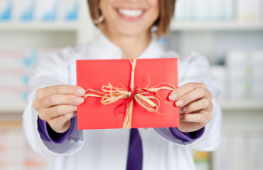 Foto/Grafik Quelle: shutterstock.com [141294367 Friendly chemist giving a red card in a front view shot © stockfour] 