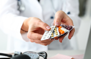 Foto/Grafik Quelle: shutterstock.com [519223267 Händepackung mit verschiedenen Tablettenblisterpackungen am Arbeitsplatz, Nahaufnahme. Panacea, lebensrettende Dienstleistungen, verschreibungspflichtiges Medikament, legales